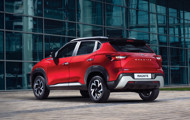Red Nissan Magnite rear view in front of building